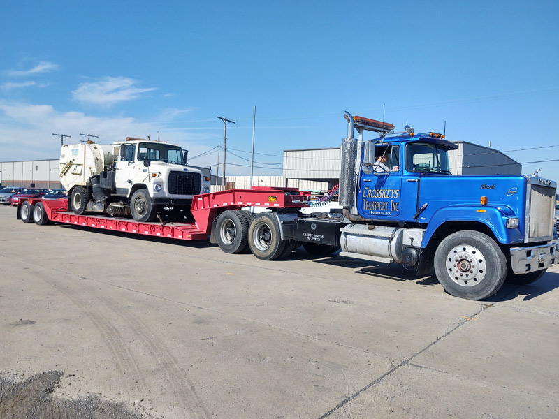 Crosskeys Towing Lowboy trailer loaded with parking lot sweeper mansfield pennsylvania